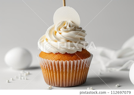 Cupcake with white cream and an inscription plate on a white background Cupcake with white cream and an inscription plate on a white background 112697079