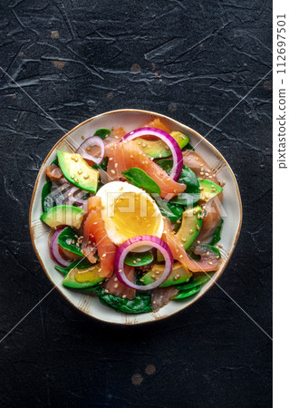 Salmon, avocado and egg salad with fresh leaves and onions 112697501