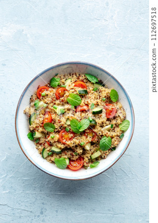 Quinoa tabbouleh salad in a bowl, a healthy dinner with tomatoes and mint Quinoa tabbouleh salad in a bowl, a healthy dinner with tomatoes and mint 112697518