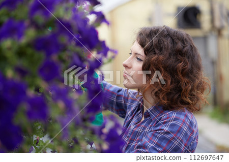 happy female nursery worker trimming plants in greenhouse happy female nursery worker trimming plants in greenhouse 112697647