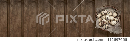 Fresh quail eggs on a cotton cloth on a wooden table. Photo with copy space. 112697666