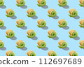 Seamless pattern of sweet rolls with green cream and soft cheese isolated on blue background. 112697689