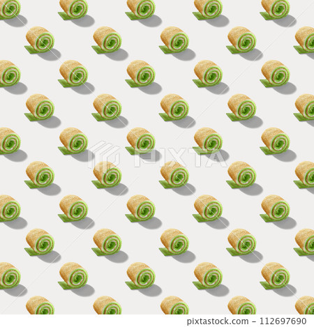 Seamless pattern of sweet rolls with green cream and soft cheese isolated on white background. 112697690