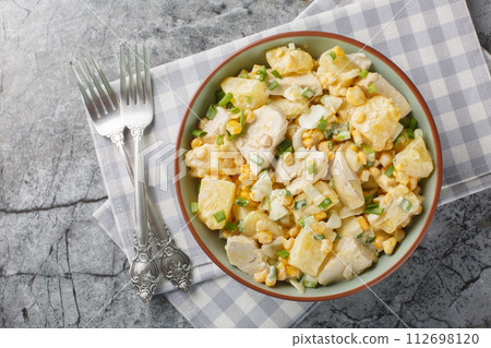 Homemade chicken breast pineapple salad with corn, cheese, eggs and onions close-up in a plate. Horizontal top view Homemade chicken breast pineapple salad with corn, cheese, eggs and onions close-up in a plate. Horizontal top view 112698120