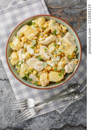 Salad of chicken, pineapple, corn, cheese and onions dressed with mayonnaise close-up in a plate. Vertical top view Salad of chicken, pineapple, corn, cheese and onions dressed with mayonnaise close-up in a plate. Vertical top view 112698124