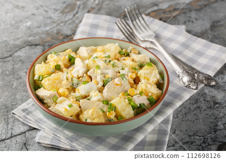 Homemade chicken breast pineapple salad with corn, cheese, eggs and onions close-up in a plate. Horizontal Homemade chicken breast pineapple salad with corn, cheese, eggs and onions close-up in a plate. Horizontal 112698126