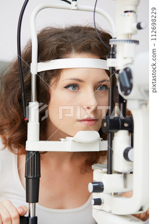 looking into eye test machine 112698229