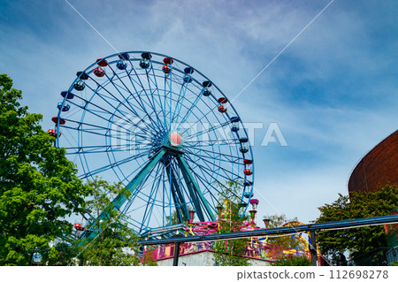Colorful ride ferris wheel in motion in amusement park on sky background. 112698278