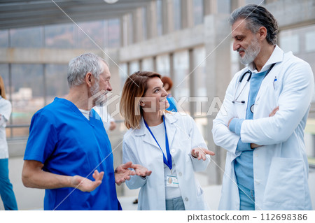 Group of doctors talking during conference. Medical networking. Medical experts attending an education event, seminar in board room. Age and gender equity in healthcare. Group of doctors talking during conference. Medical networking. Medical experts attending an education event, seminar in board room. Age and gender equity in healthcare. 112698386