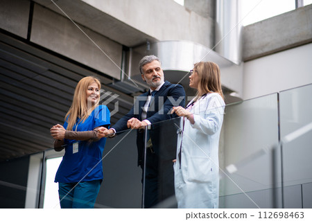 Doctors talking to pharmaceutical sales representative, presenting new pharmaceutical product. Hospital manager talking with doctors team. 112698463
