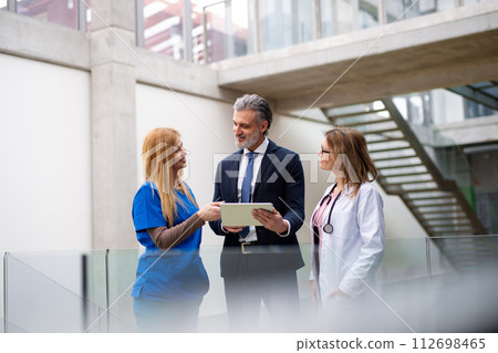 Doctors talking to pharmaceutical sales representative, presenting new pharmaceutical product. Hospital manager talking with doctors team. Doctors talking to pharmaceutical sales representative, presenting new pharmaceutical product. Hospital manager talking with doctors team. 112698465