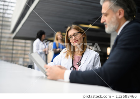 Doctor talking to pharmaceutical sales representative, shaking hands. Hospital manager talking with female doctor. Doctor talking to pharmaceutical sales representative, shaking hands. Hospital manager talking with female doctor. 112698466