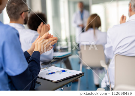 Group of doctors on conference, medical team clapping after speech. Medical experts attending an education event, seminar in board room. 112698489