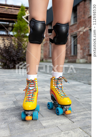 Woman trying on her new rollerblades 112698530