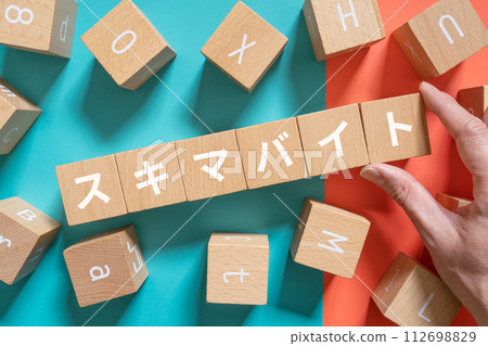 A hand holding a block containing the letters Sukima Byte A hand holding a block containing the letters Sukima Byte 112698829