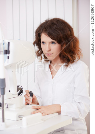 looking into eye test machine 112698907