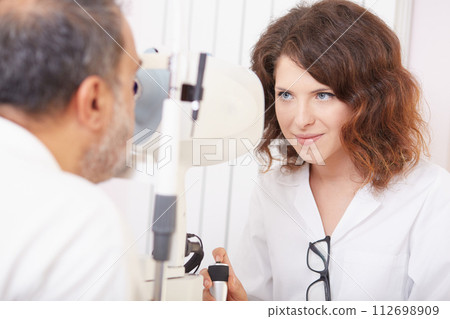 looking into eye test machine 112698909