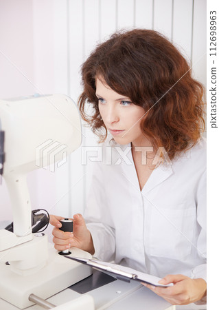 looking into eye test machine 112698963