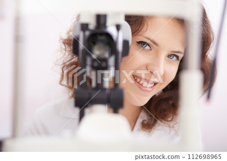 looking into eye test machine 112698965