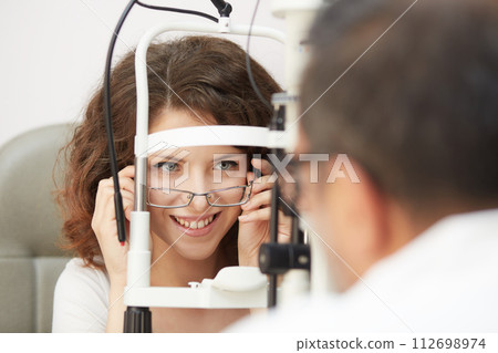 looking into eye test machine 112698974