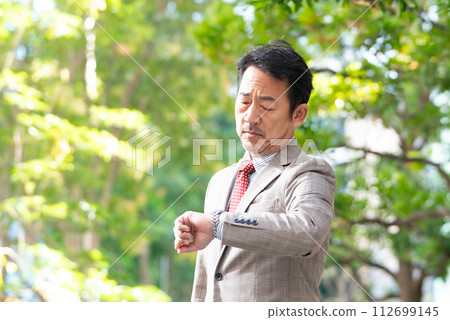 Businessman looking at the clock Businessman looking at the clock 112699145