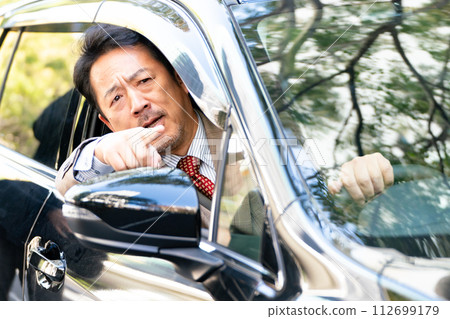 Businessman driving a car gets angry Businessman driving a car gets angry 112699179