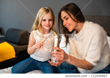 Mother and daughter with aroma candle in hotel room Mother and daughter with aroma candle in hotel room 112699967