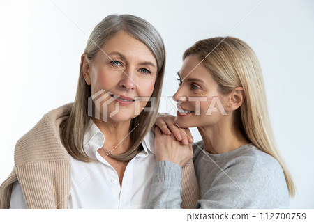 Mother and daughter feeling good with each other and looking contented Mother and daughter feeling good with each other and looking contented 112700759