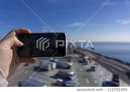 People taking pictures of Umihotaru PA and Tokyo Bay Aqua Line with smartphones 112701489