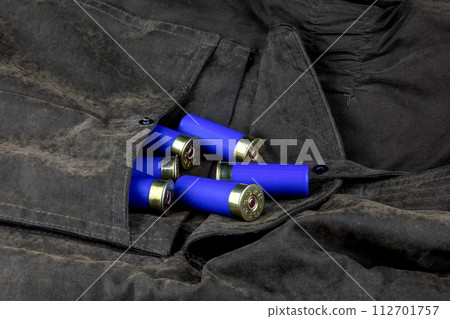 Shotgun Cartridges Spilling from an Outdoor Field Jacket Pocket Shotgun Cartridges Spilling from an Outdoor Field Jacket Pocket 112701757