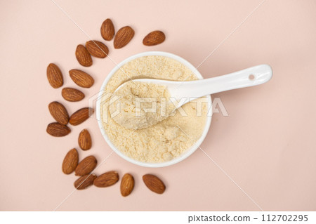 Almond flour and almonds on a pink background top view 112702295