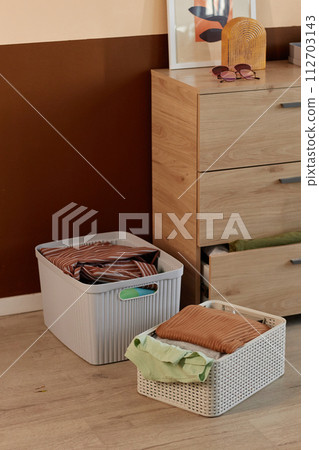 Background image of clean clothes in stacks and storage boxes in home interior Background image of clean clothes in stacks and storage boxes in home interior 112703143