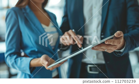 Professional business people standing in office with with digital tablets. Generative AI 112703239