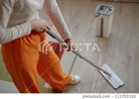 High angle closeup of young woman mopping floor at home while doing house cleaning copy space 112703330