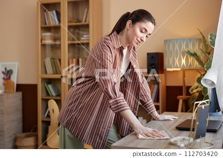 Side view portrait of smiling woman cleaning table while enjoying Spring housecleaning copy space Side view portrait of smiling woman cleaning table while enjoying Spring housecleaning copy space 112703420