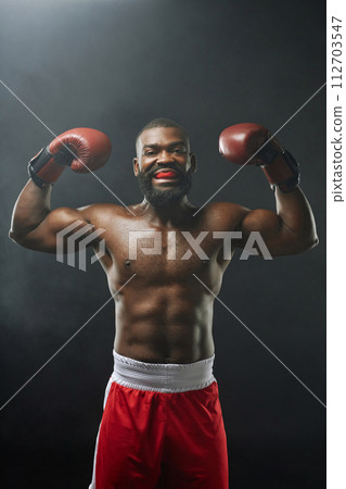 Vertical portrait of intimidating African American boxer screaming and wearing mouth guard Vertical portrait of intimidating African American boxer screaming and wearing mouth guard 112703547