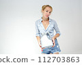 Smiling woman holding detergent bottle for machine wash. Isolated studio portrait on white. 112703863