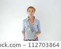 Smiling woman holding detergent bottle for machine wash. Isolated studio portrait on white. 112703864