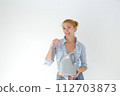 Smiling woman holding detergent bottle for machine wash. Isolated studio portrait on white. 112703873