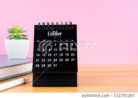 October Mini desk calendar for 2024 year on worktable with pink background. 112705267