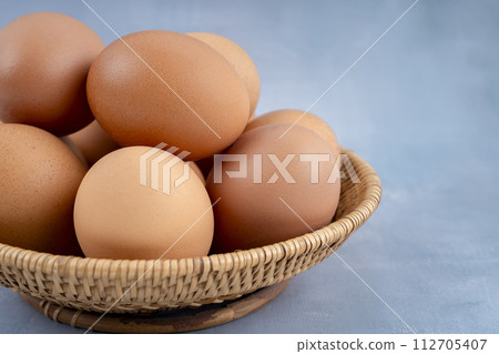 Freshness chicken eggs in wooden weave basket on blue wooden. 112705407
