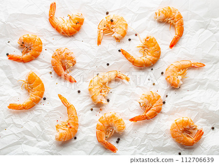 Roasted or grilled shrimps with seasonings top view on baking paper, healthy snack or appetizer. Seafood barbecue, food ingredient for salads 112706639