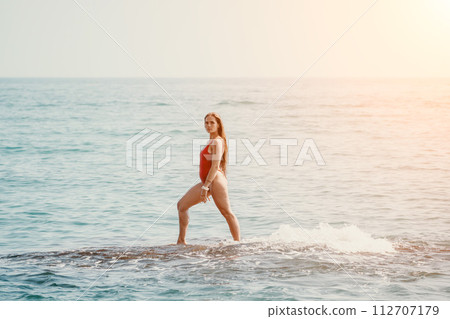Woman sea yoga. Happy woman meditating in yoga pose on the beach, ocean and rock mountains. Motivation and inspirational fit and exercising. Healthy lifestyle outdoors in nature, fitness concept. 112707179