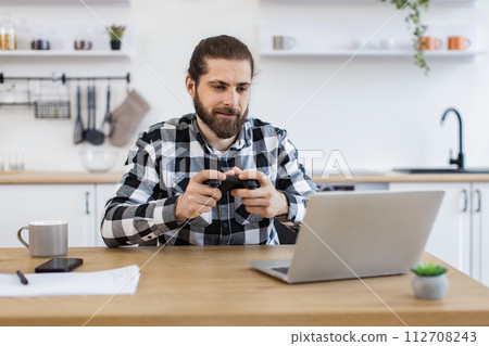 Male freelancer taking break and plays video games after work. Male freelancer taking break and plays video games after work. 112708243