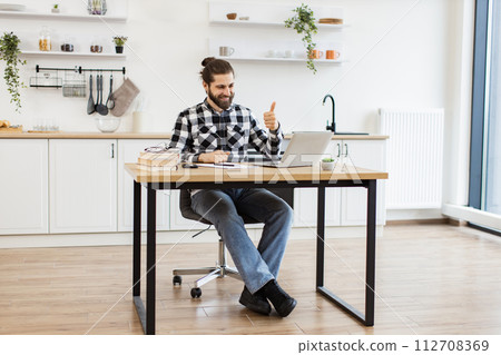 Positive entrepreneur discussing company issues using computer in apartment. 112708369