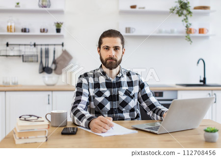 Businessman with pen making notes on draft of paper document. Businessman with pen making notes on draft of paper document. 112708456