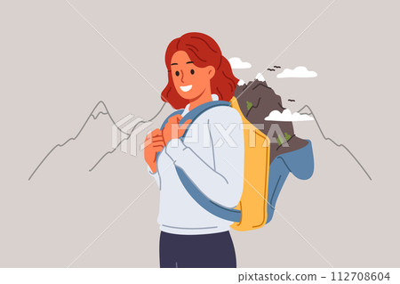 Woman goes hiking in mountains, posing in outdoor clothing with backpack for personal belongings 112708604