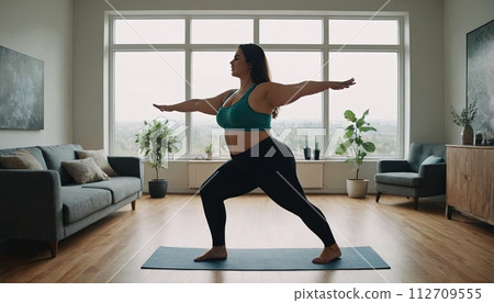 AI-generated content. Large woman, yoga practice near sofa, leggings and top attire. Bright room, large window, floor-standing flower. 112709555