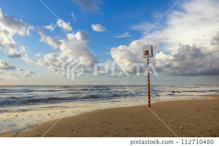 post with a sign you can't play on the seashore post with a sign you can't play on the seashore 112710480