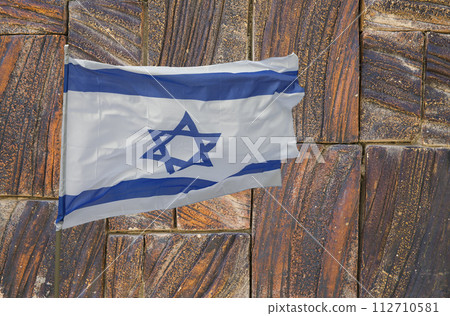 Israeli flag against the background of a stone wall 112710581